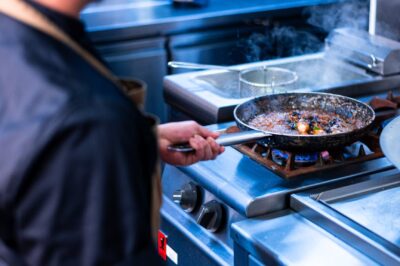 a man in an apron cooking food in a kitchen